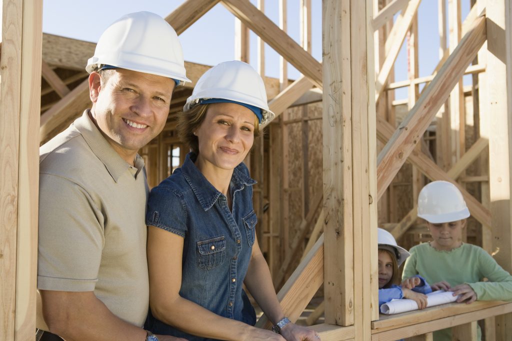 Family with two children (6-9) at construction site, portrait
