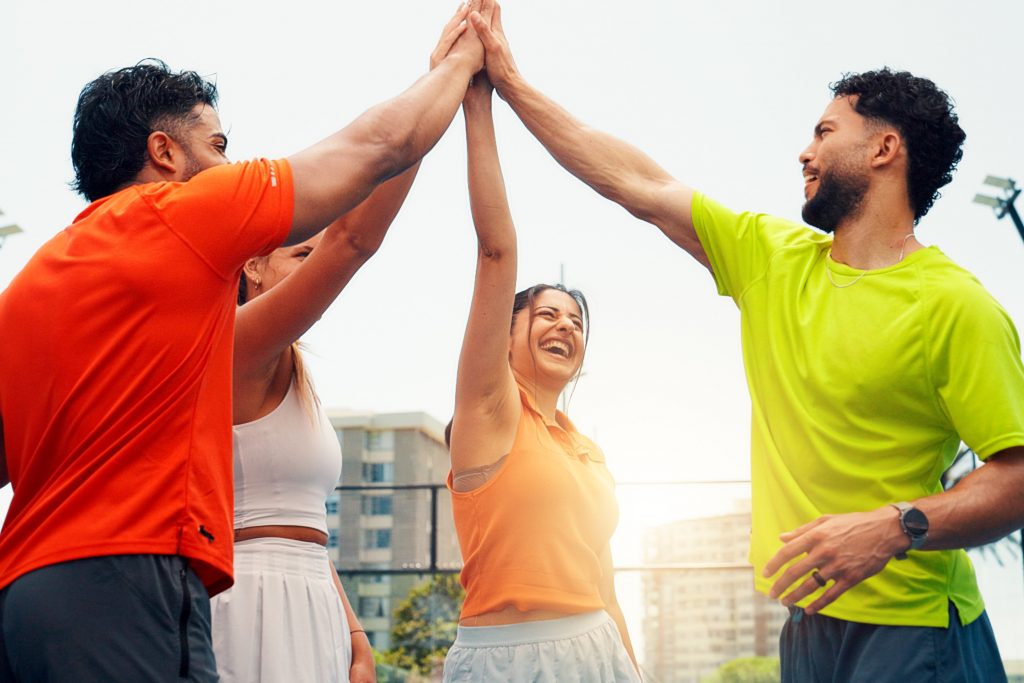 4 Freunde machen Sport und klatschen die Hände zusammen