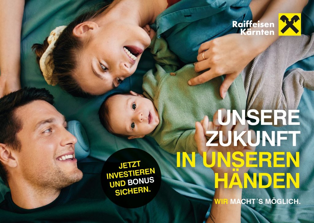 Eine Familie mit einem Baby liegt am Boden und lächelt in die Kamera
